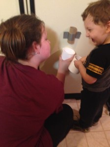 Miss Neenee & Mr. Sweetie Pants playing a game of drop the pompom through the toilet paper roll & catch it.